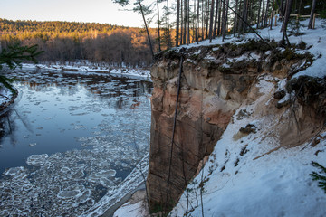 river of gauja in latvia in winter with floating ice blocks