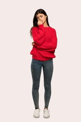 A full-length shot of a Teenager girl with red sweater having doubts over isolated background