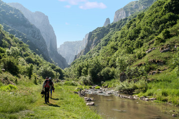 Fototapeta na wymiar Climbers walking through a valley next to a river