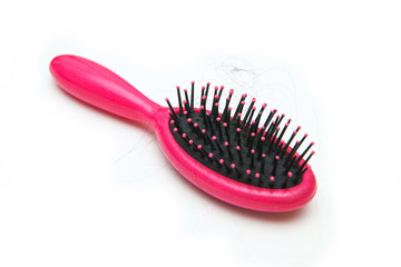 Pink hairbrush with some hair on it. Symbolises the hair loss of woman. 