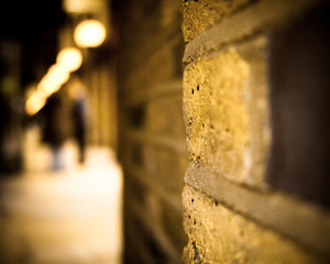 blurred people next to brick wall