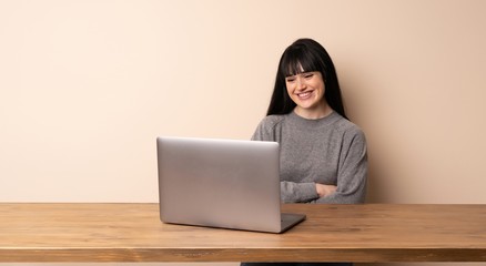 Young woman working with her laptop keeping the arms crossed in frontal position
