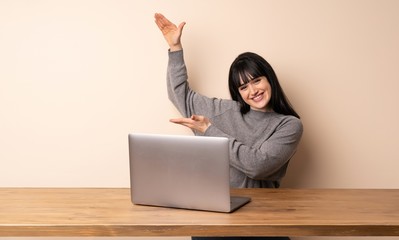 Young woman working with her laptop holding copyspace to insert an ad