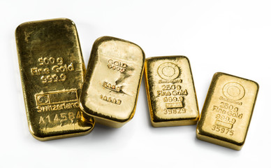Four a cast gold bars of different weight isolated on white background.