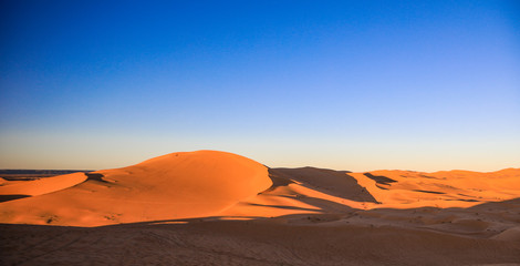Fototapeta na wymiar Orange Sands of the Sakhara Desert and Blue Sky, Algeria