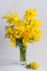 Bouquet of spring flowers in a vase. Mimosa and daffodils.