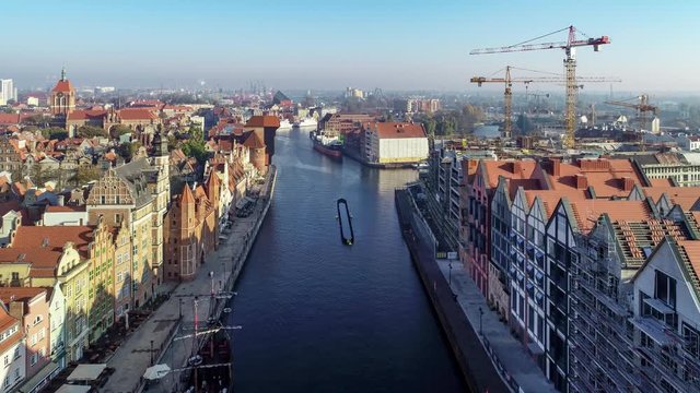 Gdansk, Poland. Motlawa River, old houses, medieval port crane (Zuraw) and new modern quarter in traditional style under construction on the Granary Island ruined in the II World War. Aerial video