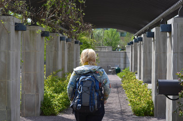 Young woman tourist wearing a backpack wanders through the US Botanical Gardens, exploring the...