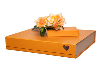 Gift box isolated. Close-up of a big and a small golden gift box with a bouquet of beautiful orange roses on it isolated on a white background. Mothers day, valentine, wedding, birthday or other festi
