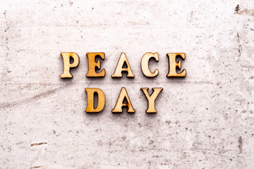 Inscription PEACE DAY in wooden letters on a light background