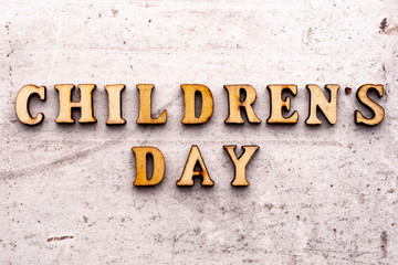 Inscription CHILDRENS DAY in wooden letters on a light background