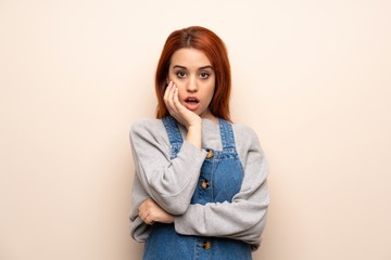 Young redhead woman over isolated background surprised and shocked while looking right