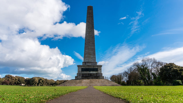 Alley leading to Wellington Monument and Testimonial (finished in 1861), the largest obelisk in Europe located in Phoenix Park, Dublin, Ireland, under a dramatic spring morning sky.