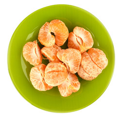 Top view. Peeled slices of mandarin on a green plate on a white background.