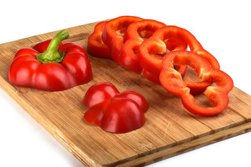 Red bell pepper cut into pieces on a wooden cutting board