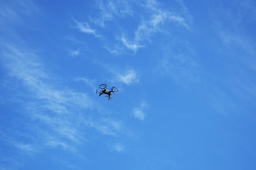 Naklejka na ściany i meble Drone in flight against the sky, new technologies in aerial photography.