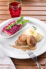 mashed potatoes and meatball and glass of juice on wooden table