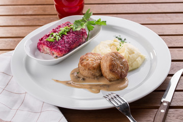 mashed potatoes and meatball and glass of juice on wooden table