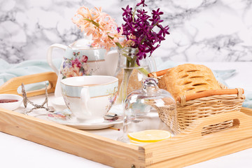 Morning tea concept. Flowers, tea and strudel on a tray