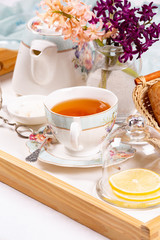 Morning tea concept. Flowers, tea and strudel on a tray
