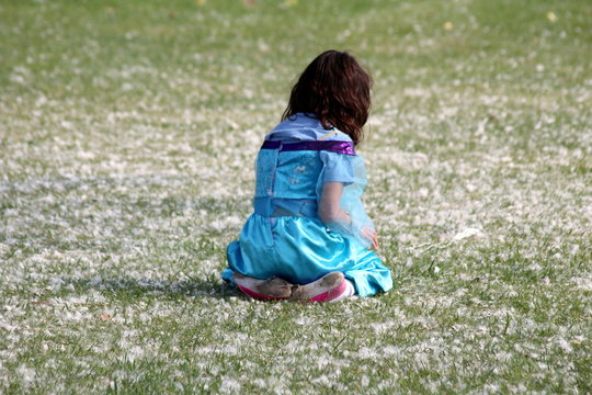 little girl sitting on the grass disguised as arab belly dancer