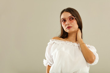 Slim young woman in white summer dress and pink sunglasses 