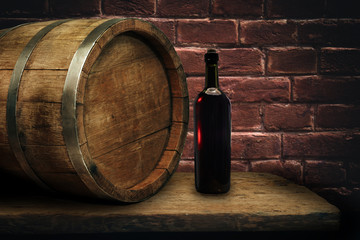 Red wine bottle on a old oak wooden table background barrel.