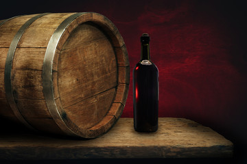 Red wine bottle on a old oak wooden table background barrel.