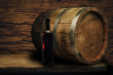 Red wine bottle on a old oak wooden table background barrel.