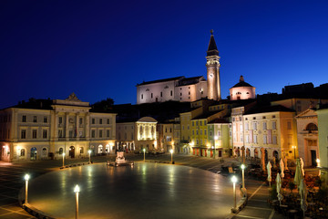 Fototapeta premium Empty Tartini Square in Piran Slovenia with City Hall, Tartini statue, St. George's Parish Church with baptistry, and St Peter's church at dawn