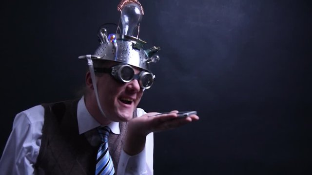 Nerd with aluminum hat looks at his cellphone with empty placeholder for animations