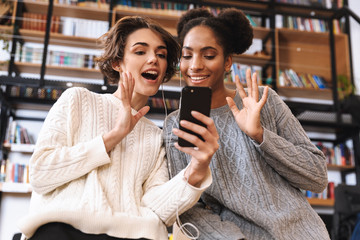 Two cheerful young girls students studying