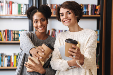 Two cheerful young girls students studying