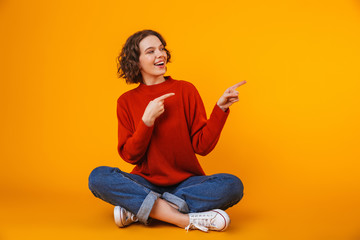 Emotional young pretty woman posing isolated over yellow wall background showing copyspace.