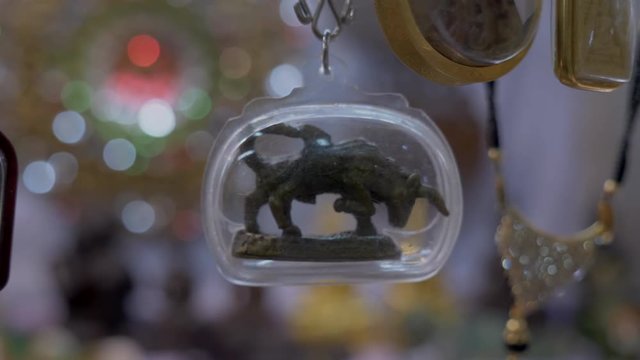 Close up of a buddhist Bull in an amulet necklace. Protection Asia