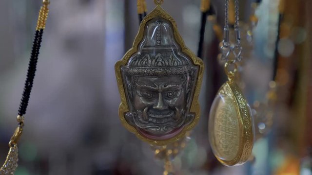 Close up of a Buddhist face amulet necklace for protection in Asia