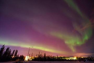 In frame there is lilac starry sky with green lights northern shine