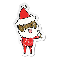 man with beard sticking out tongue wearing santa hat