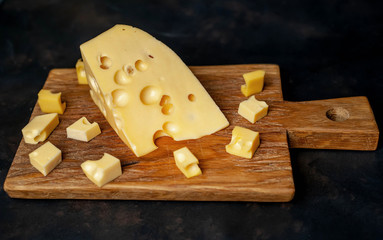 delicious cheese on a cutting board, background stone
