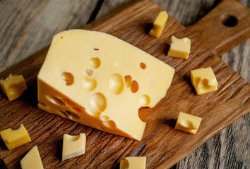 delicious cheese on a cutting board, background stone