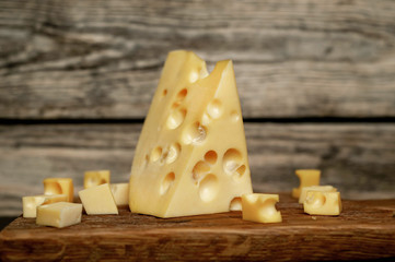 tasty cheese on a cutting board, wooden background
