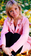 woman in the Park in a pink wool jacket enjoys the sun and enjoys life