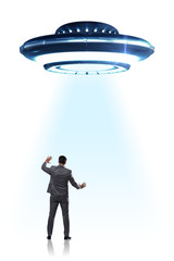 Fototapeta na wymiar Flying saucer abducting young businessman 