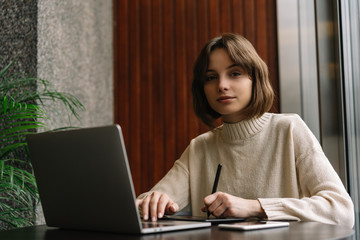 Graphic designer freelancer working project, using laptop computer and digital drawing tablet,...