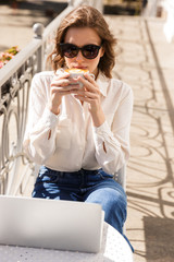 Fototapeta premium Smiling young businesswoman sitting at the cafe