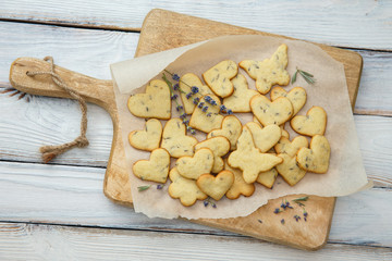 Lavender cookies on cutting board, on white baking paper