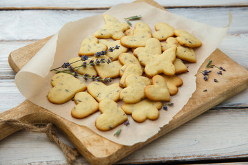 Lavender cookies on cutting board, on white baking paper