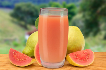 fresh guava juice in glass cup on wooden table background of nature and farm