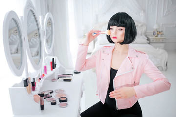 Fashion freak. Glamour synthetic girl, fake doll with empty look and short black hair is holding...