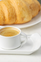 fresh croissant and a cup of hot coffee